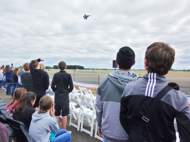 Starla Pointer / News-Register##Eighth-graders watch an F-35 fighter jet make a slow pass in front of the crowd.