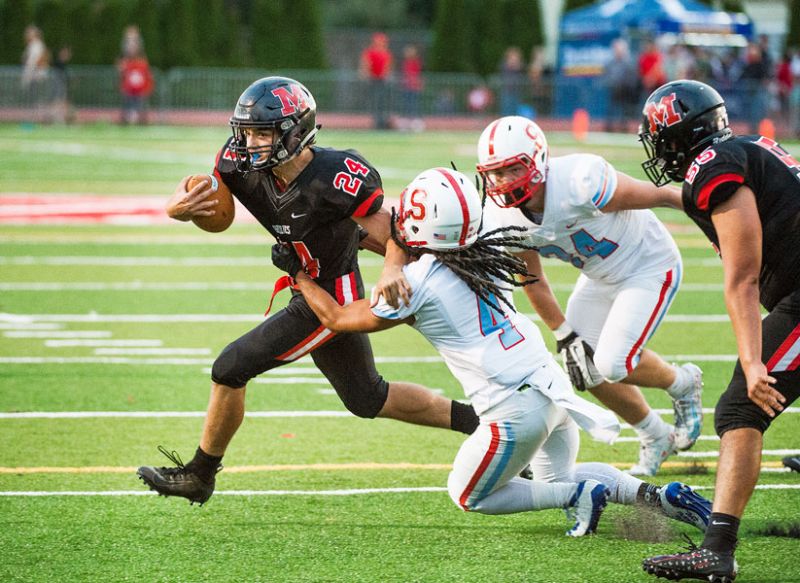 Marcus Larson/News-Register##
McMinnville s Preston Ginter sheds a tackle by Saxon defensive back Reign Bryant on his to the first score of the game and a McMinnville 7-0 lead. The Grizzlies were unable to hold the lead and dropped the contest to South Salem 24-14.