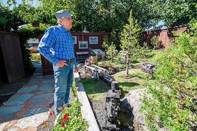 Marcus Larson/News-Register ##
Michael Crain talks about all the work that went into creating his miniature logging camp. He first built a raised bed, then added tracks and buildings.