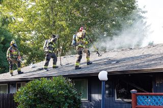 Marcus Larson/News-Register##
Firefighters from Newberg walk carefully as they check for roof stability on a burned out apartment building.