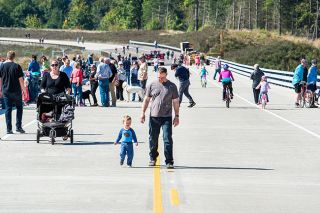 Marcus Larson/News-Register##
Stan Fuhman walks with his son Nathaniel down the center line of the Dundee bypass during Saturday s Play on the Bypass event.