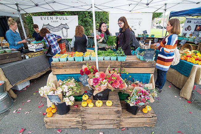 Marcus Larson / News-Register## Linfield College students Rachel Goines and Ashley Sellers choose flowers and produce at the McMinnville Farmers  Market Tuesday.