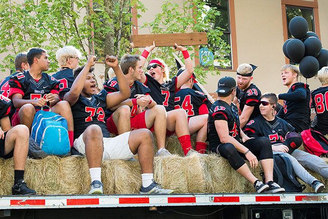 Marcus Larson / News-Register##Members of the McMinnville High School football team cheer as they ride down Third Street Thursday afternoon. They will compete againgst Centennial High School players tonight.