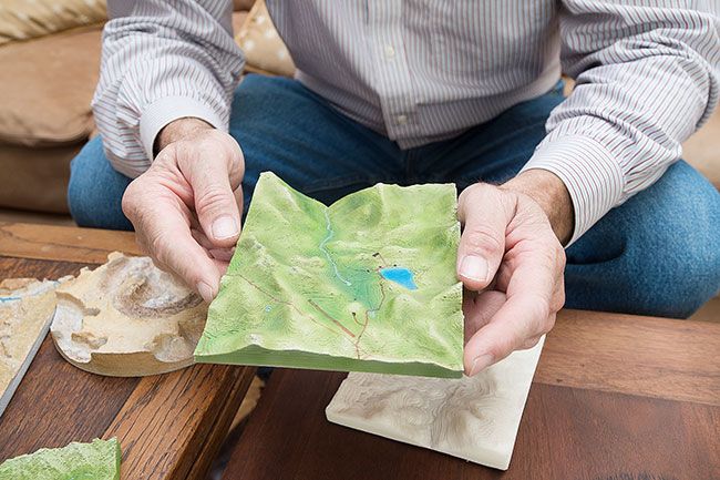 Marcus Larson/News-Register##Kleemann holds a three-dimensional map of the ranch he owns in Southern Oregon. He flew a drone over the landscape snapping photos, fed the digital information into his computer, then printed the map on his 3-D printer. The final step was adding tint to make it look more realistic.