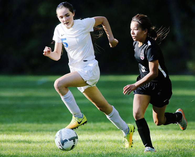 Rockne Roll/News-Register##
April Anguiano of Dayton , right, looks for a passing option in Monday s match between the Pioneers and the Pirates at Western Mennonite School in Perrydale.