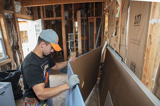 Rusty Rae/News-Register##

Remy Flores Jr. cuts a piece of sheetrock which his father, Remy Sr., will place on the interior walls of one of the new Boutique Retreat tiny homes. The nightly lodging resort is expected to open in November on Alpine Avenue in McMinnville.