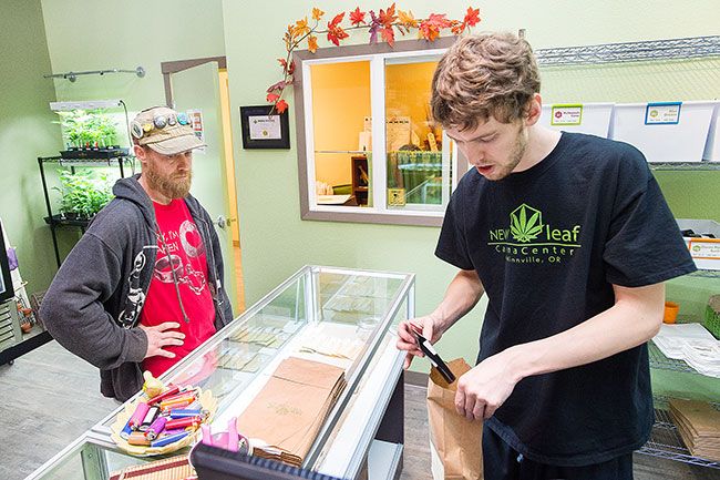 Marcus Larson/News-Register##Steven Perkins purchases some marijuana from Jerod Bogh of New Leaf in McMinnville. Oct. 1 was the first day of legal recreational marijuana sales. Possession of marijuana was made legal July 1.