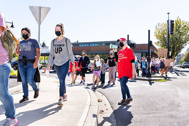 Marcus Larson/News-Register##Women’s March organizer Elaine Yorks leads chants as marchers make their way north from the municipal plaza at Second and Baker streets. Organizers were prepared for counter-protesters, but none appeared.