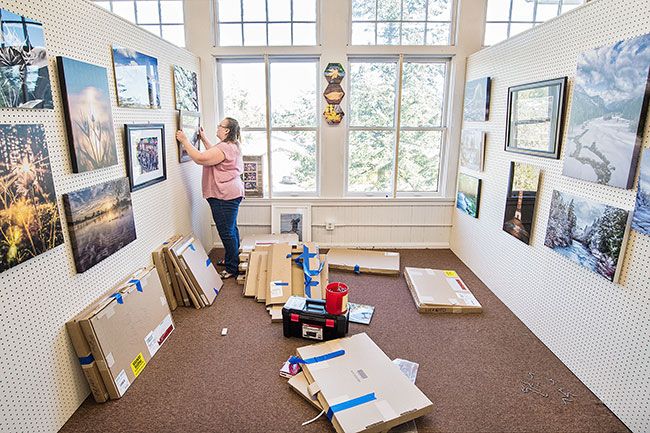 Marcus Larson/News-Register ##
Photographer Debbie Lockwood carefully hangs several of her pictures in her new space at the Lafayette Schoolhouse Antique Mall. The mall is being converted to a collection of fine art and craft booths, as well as antiques.