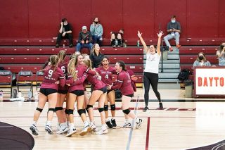 Rusty Rae/News-Register##
The Dayton volleyball squad, with head coach Megan Webster, erupts in excitement after defeating rival Amity in four sets during Tuesday’s PacWest Conference matchup.