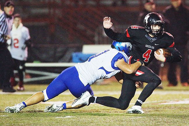 Rockne Roll/News-Register##
McMinnville s Tyler Sitton (4) is hauled down in the Grizzlies  game against McNary on Friday, Oct. 7, at Wortman Stadium.