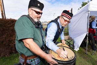 Marcus Larson/News-Register##After the opening ceremony parade, Ryan Shannon has fellow drummer Brain Campbell sign the top of his drum to remember those who participated in this year’s McMinnville Scottish Festival.