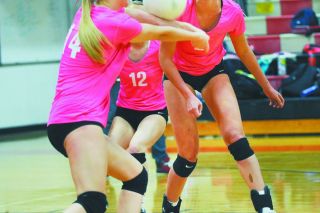 Rusty Rae/News-Register##
Alyssa Anderson (14) sets a ball as Jamie McCullough (12) and Avari Ridgway (2) look on.