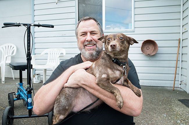 Marcus Larson/News-Register ##
Michael Pollock holds Scrumpy, whom he adopted from Homeward Bound Pets. He doesn’t leave home without her — except when he goes to the store, since he won’t leave Scrumpy locked in his truck