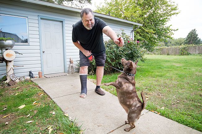 Marcus Larson/News-Register ##
Michael Pollock plays with his dog, Scrumpy. She loves treats — maybe too much, he said indulgently.