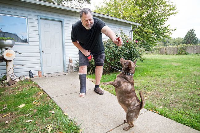 Marcus Larson/News-Register ##
Michael Pollock plays with his dog, Scrumpy. She loves treats — maybe too much, he said indulgently.