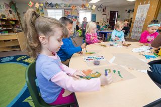 Marcus Larson/News-Register##Wascher preschooler Luna Miller and fellow students paint leaves, one of many art projects that will be sent to a survivors of the mass shooting in Las Vegas.