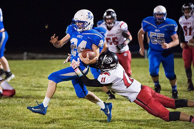 Marcus Larson/News-Register##
Amity running back Brian Hatch evades a tackle from a Clatskanie defender.