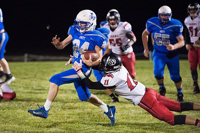 Marcus Larson/News-Register##
Amity running back Brian Hatch evades a tackle from a Clatskanie defender.