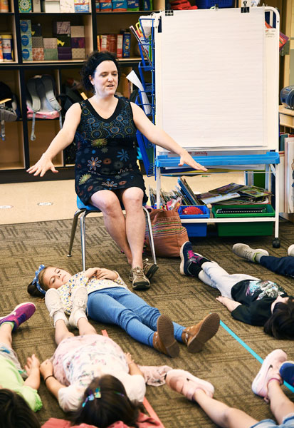 Rusty Rae/News-Register##Leading a mindfulness session, Fleckenstein encourages students to relax. Teaching meditation skills to children “brings meaning and purpose to my life,” she said.