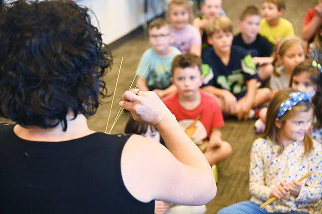 Rusty Rae/News-Register##During a mediation session with first-graders, Fleckenstein talks about the “spaghetti” exercise, in which children make their muscles stiff like dry spaghetti, then relax them like wet noodles.