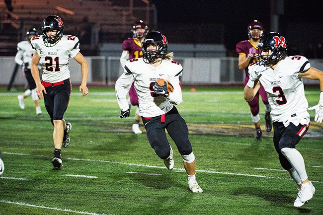 Marcus Larson/News-Register##
Odin Thorson heads for the end zone with an interception early in the first quarter to give McMinnville a 7-0 lead.