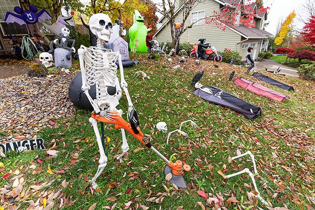 Marcus Larson/News-Register##A skeleton trims the grass at Dan and Janisse Griffin’s house, where the front yard is filled with corpses and famous Halloween movie characters. The Halloween fans were married on Oct. 31 nine years ago.