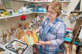 Marcus Larson/News-Register##Ann Widen shows off one of the decorative pumpkins she made with weathered boards her husband removed from their fence. The stems came from real pumpkins at Draper Farms. Marcus Larson/News-Register##Ann Widen shows off one of the decorative pumpkins she made with weathered boards her husband removed from their fence. The stems came from real pumpkins at Draper Farms.