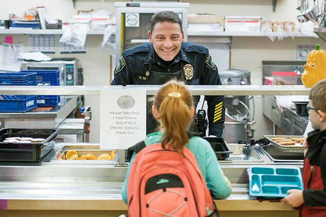 Rusty Rae/News-Register ##
Chief Kevin Martinez is all smiles as he takes a breakfast order from a  student. Police visit the school frequently so students know them as friendly faces.