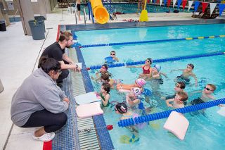 Marcus Larson/News-Register##
Swim club volunteers Nate McKay and Gehna Greenslate chat with younger
Mac Swim Club participates before the start of their training session.
The club is like a family, parents and participants said. Marcus Larson/News-Register##
Swim club volunteers Nate McKay and Gehna Greenslate chat with younger
Mac Swim Club participates before the start of their training session.
The club is like a family, parents and participants said.