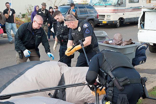 Rusty Rae/News-Register##McMinnville police Capt. Tim Symons, Officer Justin Brenner, Officer Robert Harmon and Officer Mike Maierhofer confiscate Kim Wood’s tent Wednesday on N.E. Dustin Court.