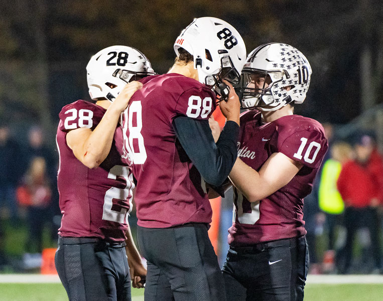 Marcus Larson/News-Register##
Nate Arce (28) and Dylan Phipps (10) comfort Charles Estrada (88) after the Pirates lost 7-6 to Santiam Christian in the first round of the 3A playoffs.