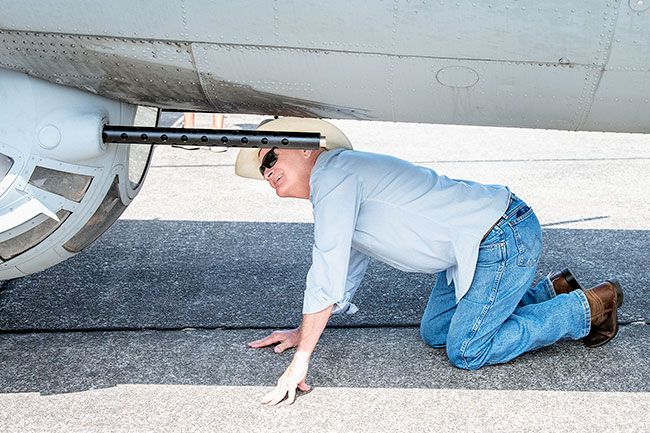 Rusty Rae/News-Register##An Air Show attendee takes a closer look at the ball turret of the B-17, Ye Olde Pub, which was parked during the three days of the show. About four feet in diameter, gunners operating the two 50-caliber machine guns rarely wore parachutes.