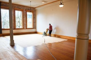 Rusty Rae/News-Register##
Contractor Armando Lopez sands original Douglas fir floorboards in the Grand McMinnville, formerly the McMinnville Grand Ballroom. The space has reopened with a new paint job, as well.