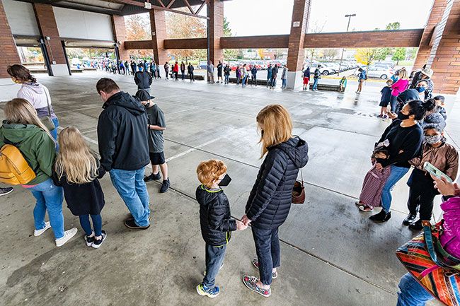 Marcus Larson/News-Register##Five-year-old Zeke Schmidt and his mother, Elsa, center, wait in line at Duniway Middle School with hundreds of others seeking COVID-19 vaccinations. The clinic gave out 187 pediatric shots on Veterans Day. Another clinic is scheduled at Duniway on Dec. 4.