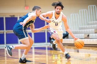 Rusty Rae/News-Register##Linfield guard Trey Bryant is tightly guarded by a Mountaineer defender. Bryant was held to seven points in the loss.