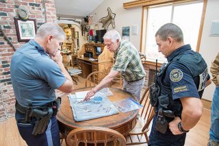 Marcus Larson/News-Register##
Local paleontologist Mike Full, center, turns over some bones found on dig that
he suspects could be human and, possibly, recent. OSP Sgt. Brad Hessell, left,
and game trooper Chris Allori accepted the bones. Marcus Larson/News-Register##
Local paleontologist Mike Full, center, turns over some bones found on dig that
he suspects could be human and, possibly, recent. OSP Sgt. Brad Hessell, left,
and game trooper Chris Allori accepted the bones.