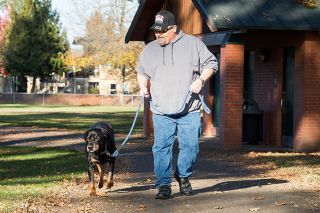 Marcus Larson/News-Register
##Rich Choate enjoys a quick walk in Wortman Park with his rottweiler, Prince. The companion dog lost his leg to cancer and is receiving chemotherapy.