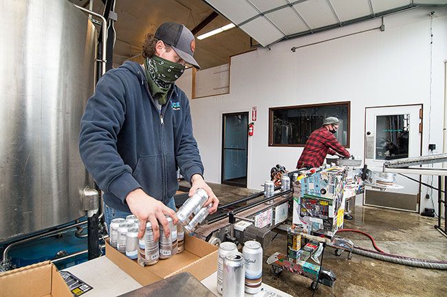 Marcus Larson/News-Register ##Julian Barton and Anthony Gibson with Vice Canning Inc. work to package the first run of ForeLand Beer, featuring a pilsner and IPA. Foreland takes over the location of Allegory Brewing, which closed earlier this year. Allegory owner David Sanguinetti is a partner in the new brewery with Sean Burke, former head brewer at Von Ebert Brewing.