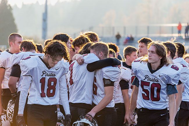 Rachel Thompson/News-Register##Hugs were aplenty after Dayton’s season ending loss on Saturday in Cottage Grove. Gavin Koch (66) hugs fellow senior Kallen Lindell (7) while senior Alex Hernandez heads off the field postgame.