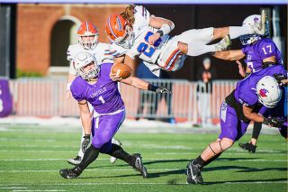 Rusty Rae/News-Register##Linfield’s Caiden Biege-Wetherbee (right, 22) takes down a hurdling Skylar Noble. The Linfield defense was able to hold the Sagehens to just 33 yards rushing.