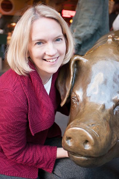 Submitted photo##McMinnville High School graduate Lillian Sherman with a giant piggy bank at Seattle s Pike Place Public Market, where she is director of the charitable foundation.