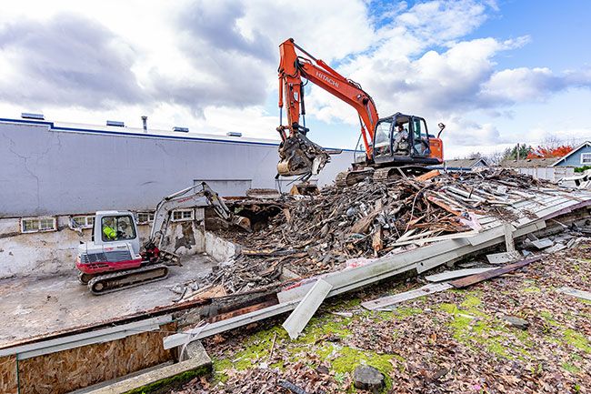 Marcus Larson/News-Register
G&P Obrist Excavating workers Mike Taylor and Mike Sayles clear out rubble from an apartment building at 429 S.E. Baker
St. that burned Nov. 30, 2020.