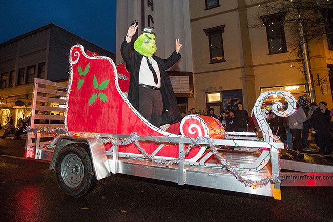 Marcus Larson/News-Register##News-Register reporter Tom Henderson waves to the crowd during the annual Santa’s Parade on Friday, dressed up as the Grinch-turned newsman.