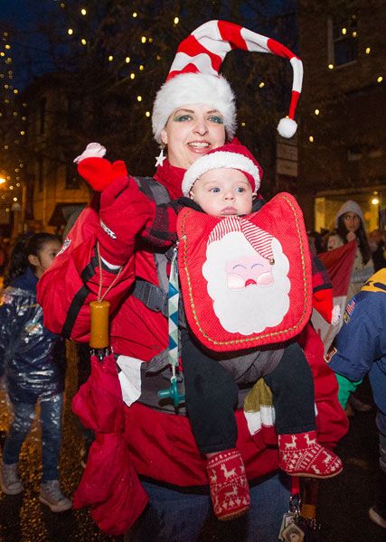 Marcus Larson/News-Register##Kirsten Park and her three-month-old baby Zachary participate in Santa’s Parade on Third Street to kick off the holiday season.