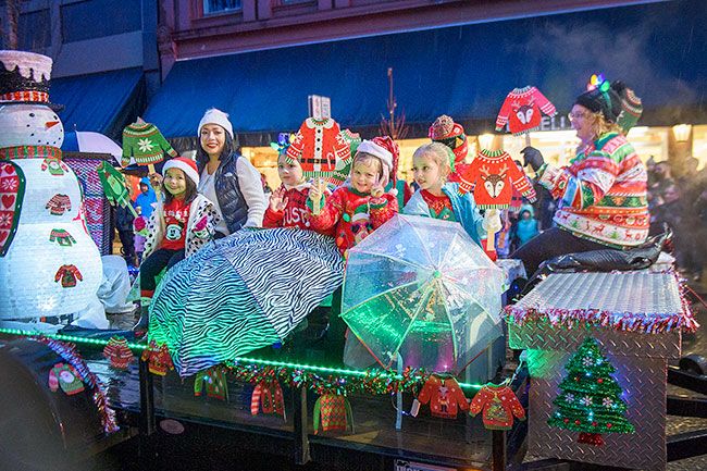 Rusty Rae/News-Register##These cherubs with wet faces brought holiday cheer to the parade, keeping the umbrellas as float adornments.