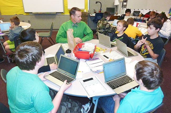 Starla Pointer / News-Register##Fifth-grade teacher Erik Svec, center, discusses a writing project with fifth-graders. Each member of this team is using one of the class Chromebooks.