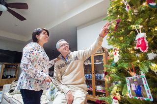 Marcus Larson/News-Register##Angel and Isabel Aguiar discuss the various homemade ornaments adorning their tree, including ones featuring childhood pictures of their kids. Marcus Larson/News-Register##Angel and Isabel Aguiar discuss the various homemade ornaments adorning their tree, including ones featuring childhood pictures of their kids.
