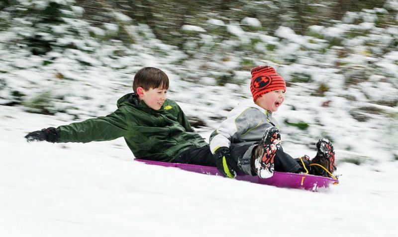 Rockne Roll/News-Register
Brothers Ledger, right, 4, and Rowan Easterday, 10, tear through Lower City Park in McMinnville on their sled Thursday.
