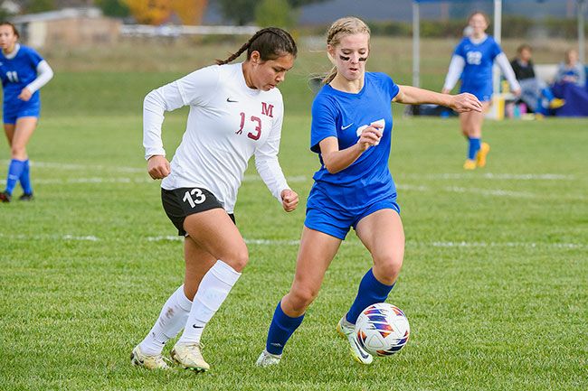 Rusty Rae/News-Register##Nisly dribbles past a McLoughlin defender during Amity’s 6-0 playoff victory on Nov. 2.